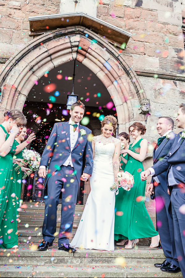 St-oswalds-wedding-malpas-bride-and-Groom-leave-church-for-natural-made-Confetti-image