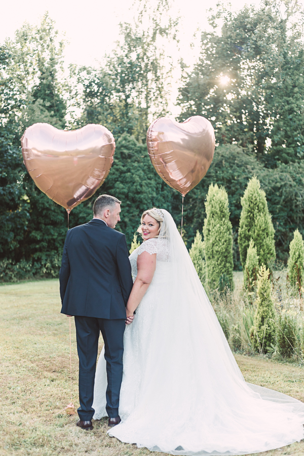Statham-lodge-golden-light-couples-portrait-Outdoor-summer-UK-wedding-Photographer-with-heart-balloons