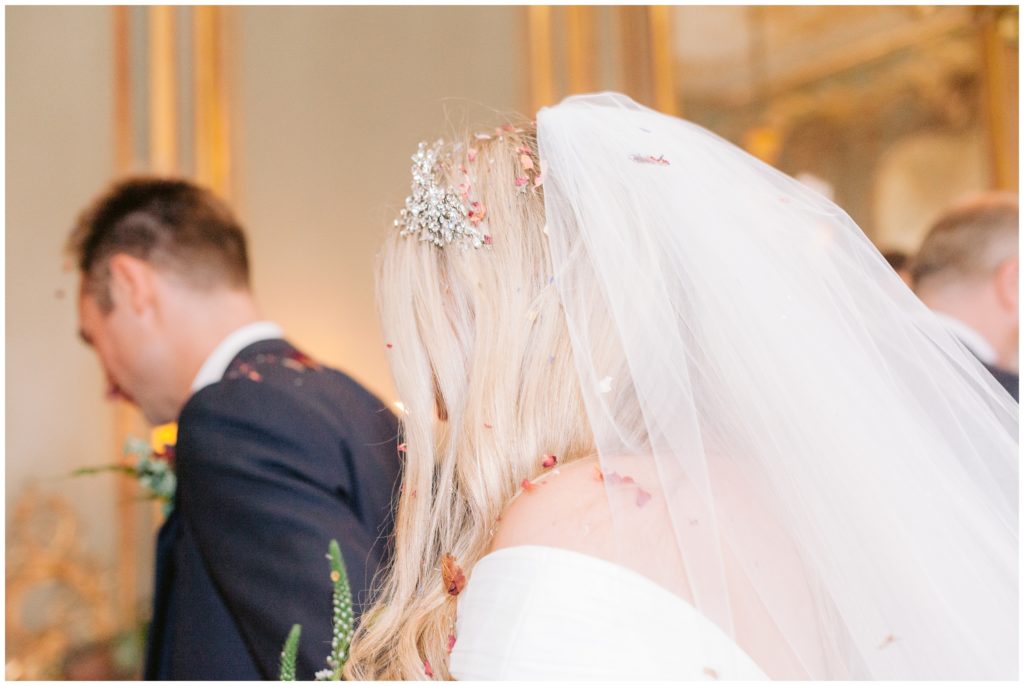 Luxury Wedding ceremony at Clivedon House in Buckinghamshire, bride and groom with dried rose petal confetti